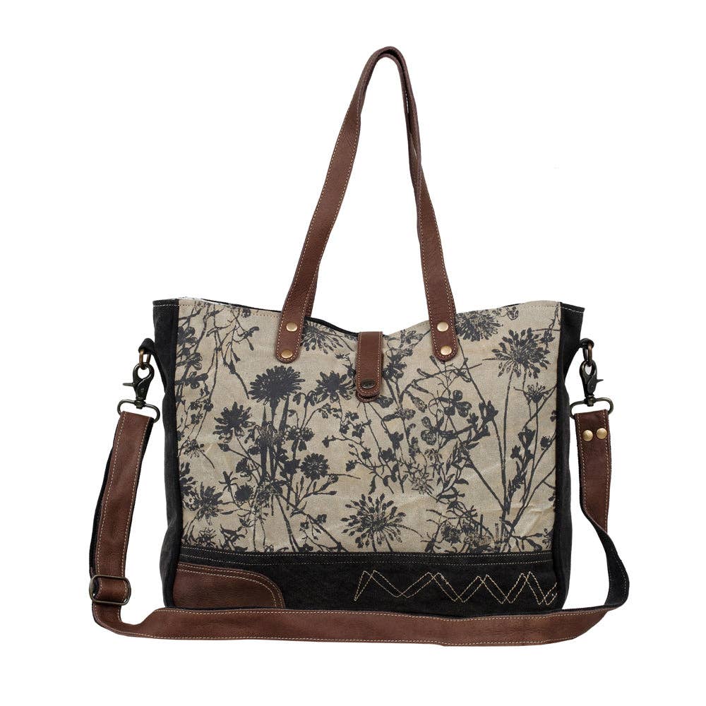 Floral-print messenger bag featuring a structured shape, multiple pockets, a shorter handle, and a longer shoulder strap.