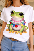 White t-shirt featuring a graphic of a frog with a jeweled collar, showcasing colorful gems and large eyes.