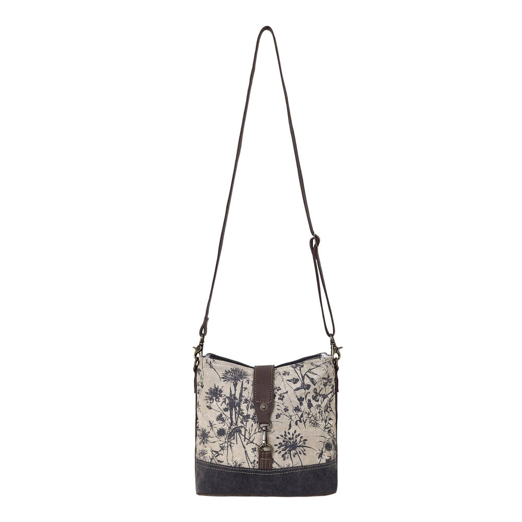Floral canvas shoulder bag featuring a front lock closure and adjustable leather strap. Perfect blend of style and functionality.