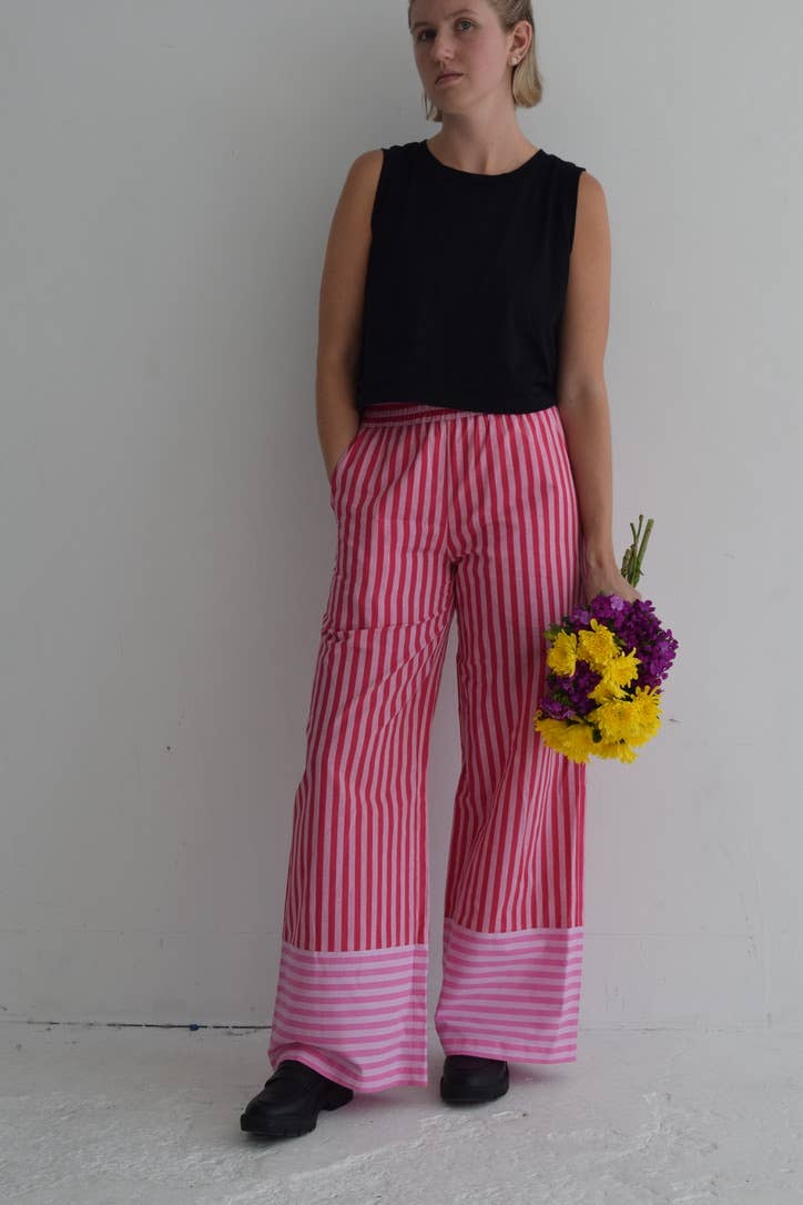 Vertical pink and red striped wide-leg pants with a contrasting hem, perfect for warm days and casual outings.