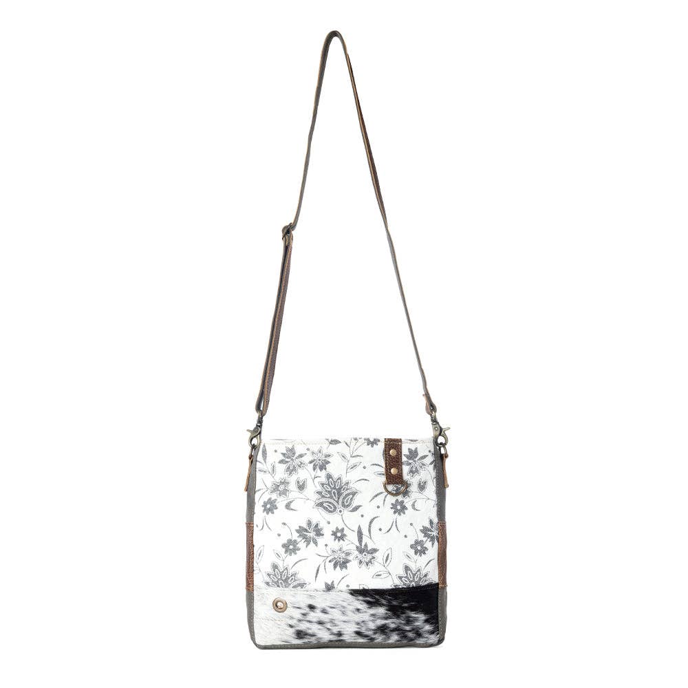 Floral design shoulder bag featuring a hairon panel, zippered top closure, and a stylish shoulder strap.