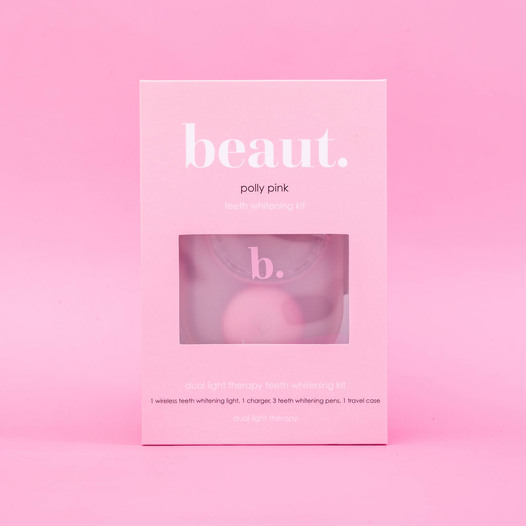 Polly Pink Kit displayed in a pink box with a window, featuring a wireless teeth whitening device and blue light therapy details.