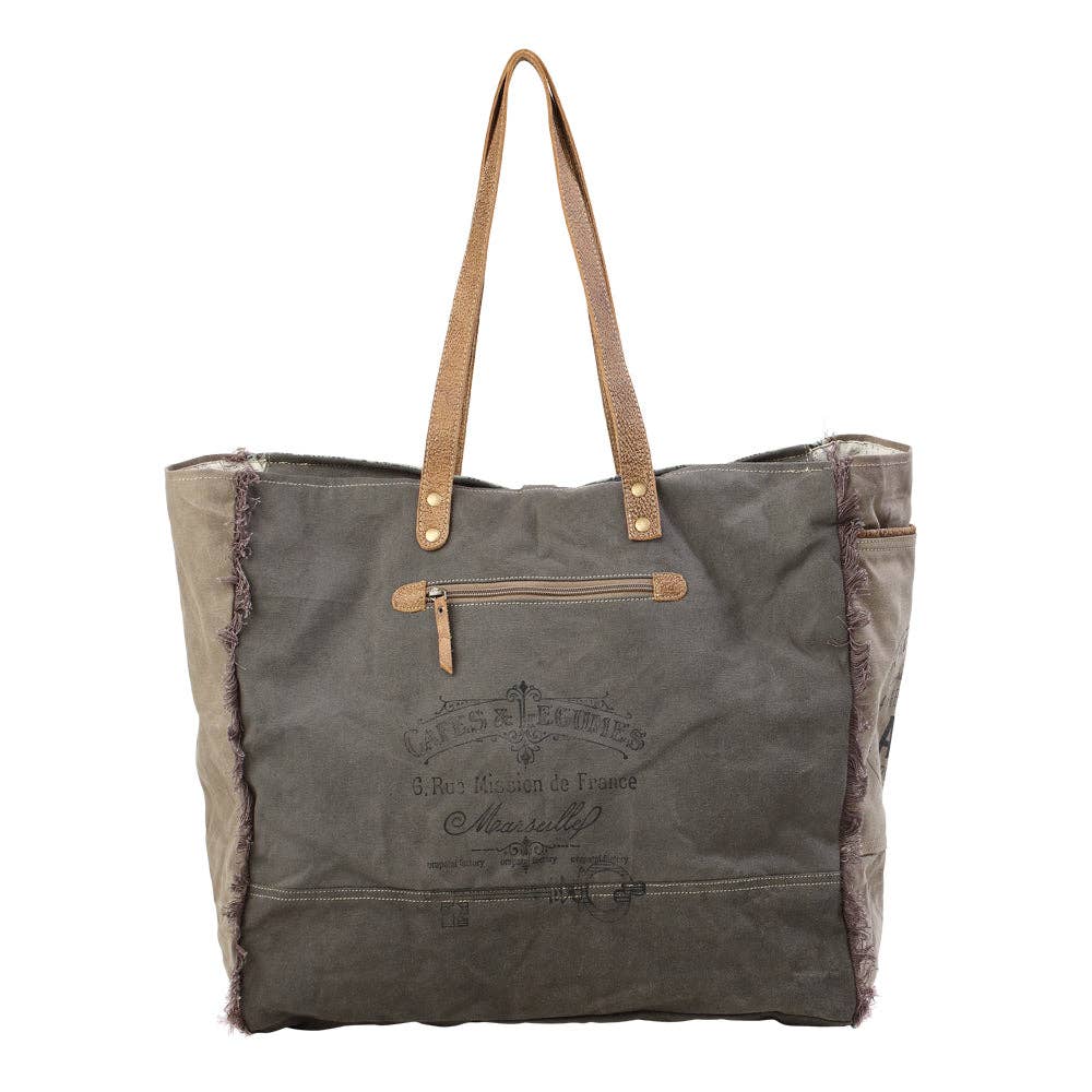 Stylish green floral print weekender bag with leather trim and large zipper closure, perfect for travel.