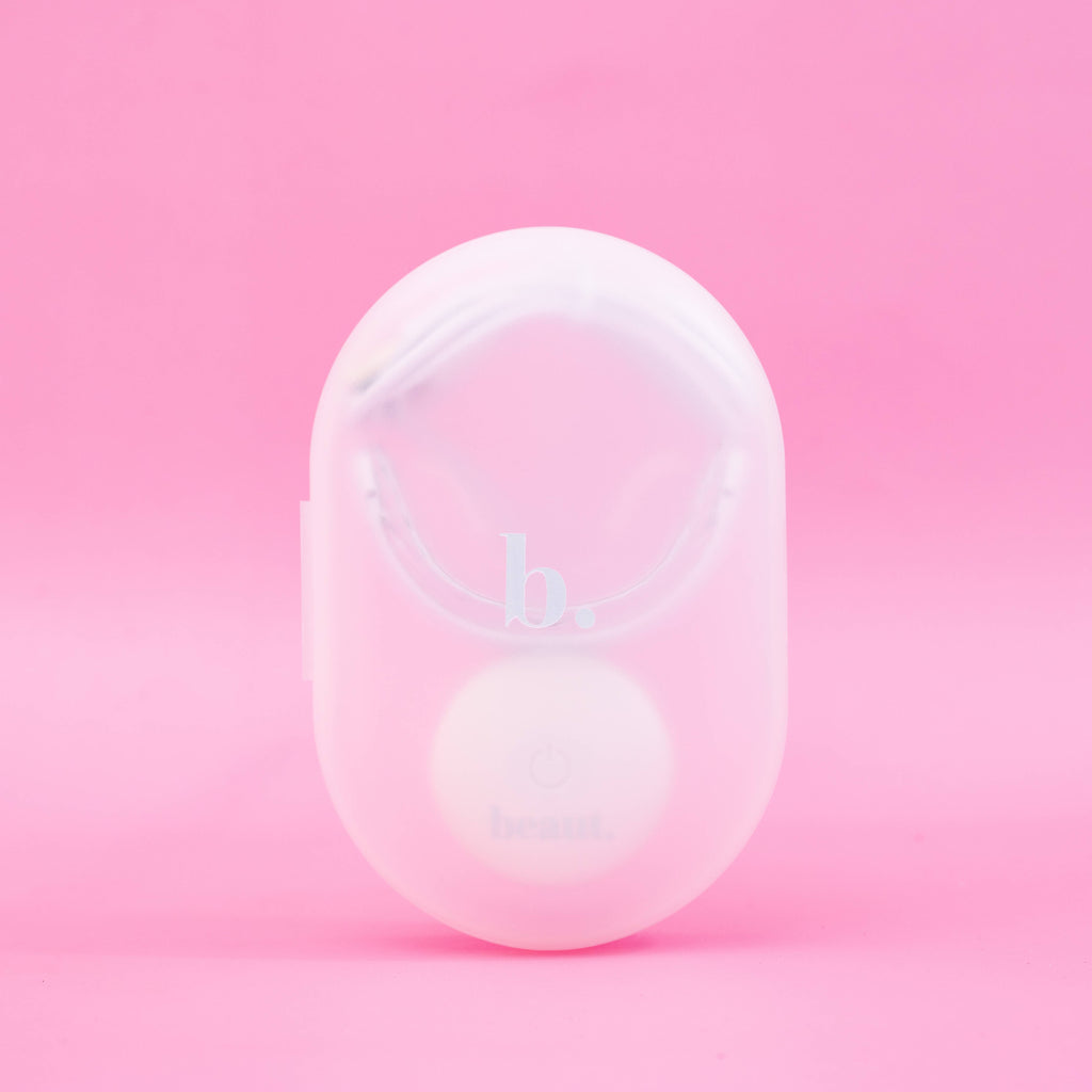 Cozy Kit device featuring a circular button, designed for blue light therapy and oral care treatments.