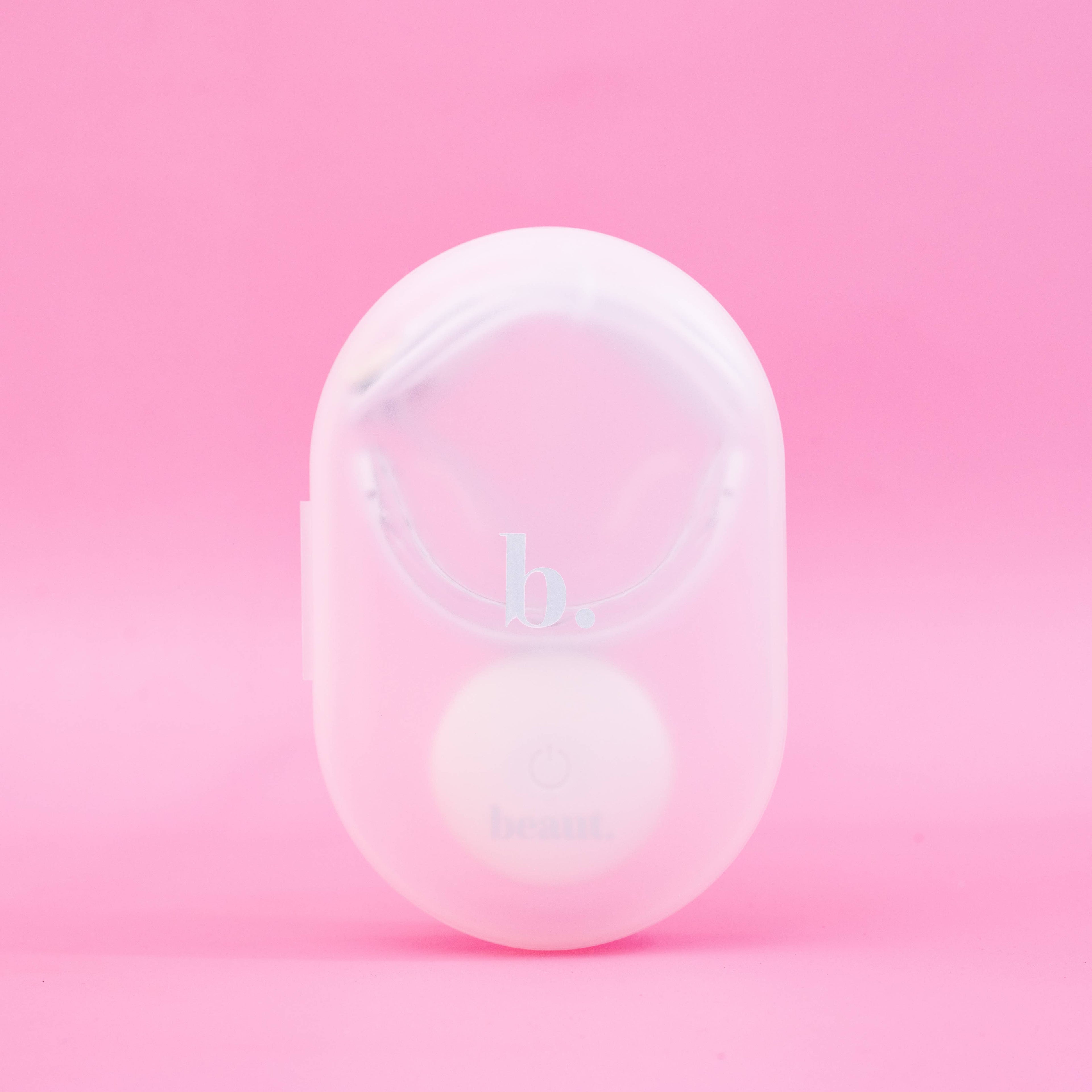 Cozy Kit device featuring a circular button, designed for blue light therapy and oral care treatments.