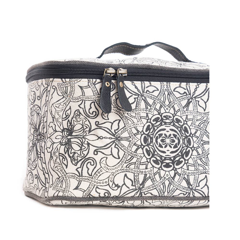 Black and white vintage-inspired toiletries bag with intricate patterns and a zippered closure, featuring a sturdy black handle.