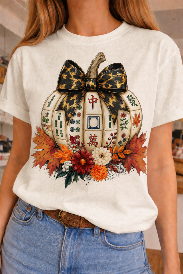 Crew t-shirt featuring a pumpkin design with Mahjong tiles, adorned with a bow and floral elements, perfect for fall game nights.