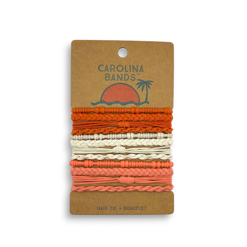 A set of braided and twisted hair tie bracelets in shades of orange, cream, and coral on a cardboard backing.