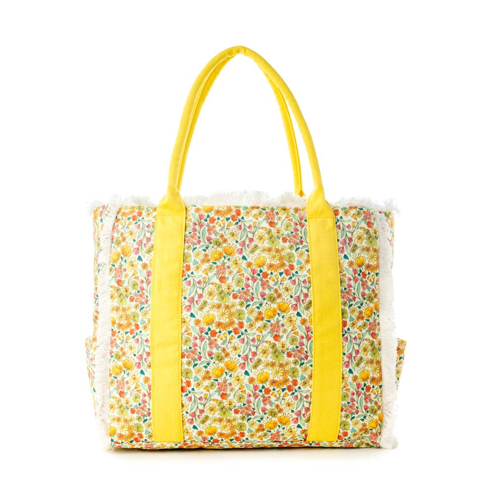 Wildflower print weekender bag with yellow background, colorful floral patterns, yellow carry straps, and fringe detailing.