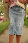 Light denim skirt featuring front and back pockets, zipper and button closure, with patched distressing on the front.