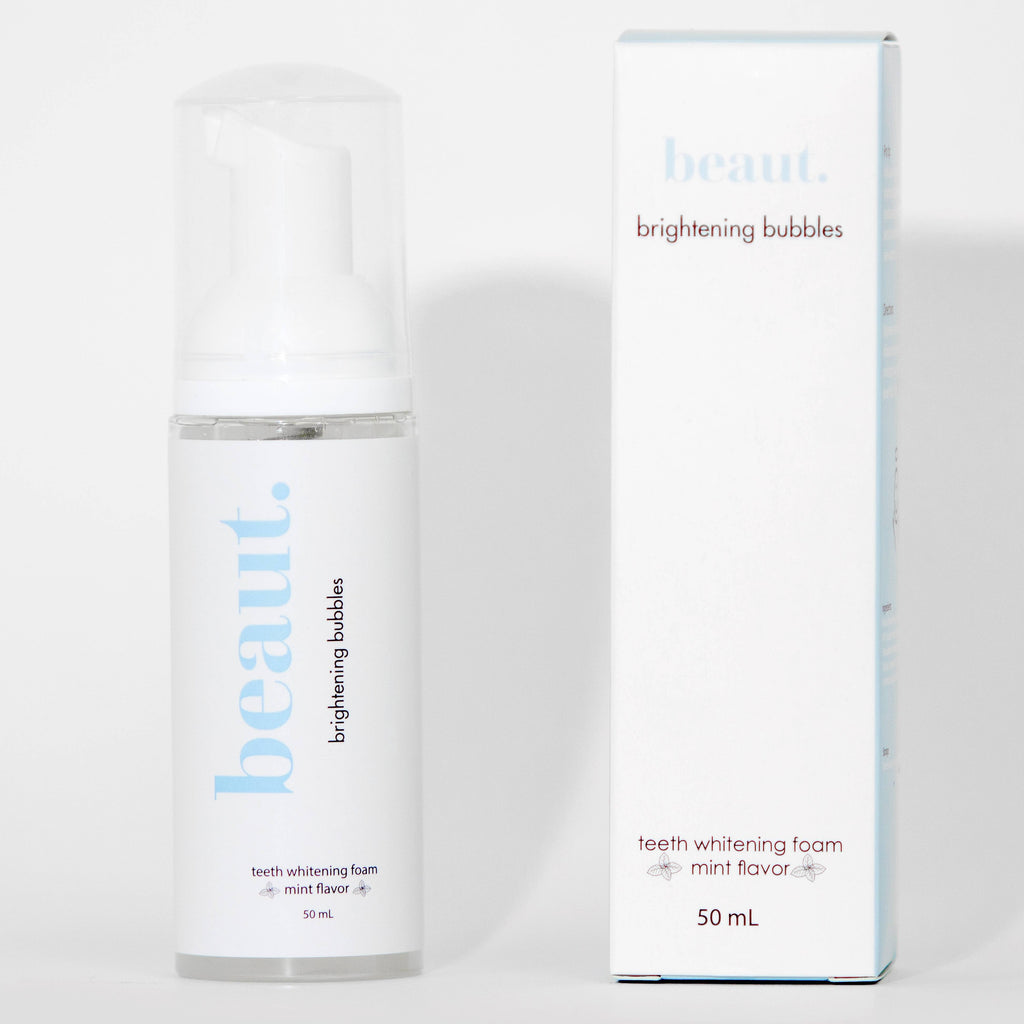 Clear pump bottle of Brightening Bubbles teeth whitening foam with a white cap and a label featuring mint flavor.