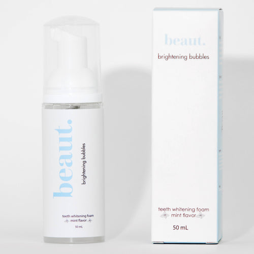 Clear pump bottle of Brightening Bubbles teeth whitening foam with a white cap and a label featuring mint flavor.