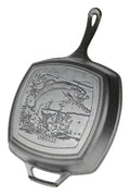Detailed rainbow trout design on a black cast iron grill pan, perfect for outdoor cooking and grilling.