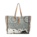 Floral print weekender bag with leather trim, featuring top handles and a zipper closure for stylish travel.