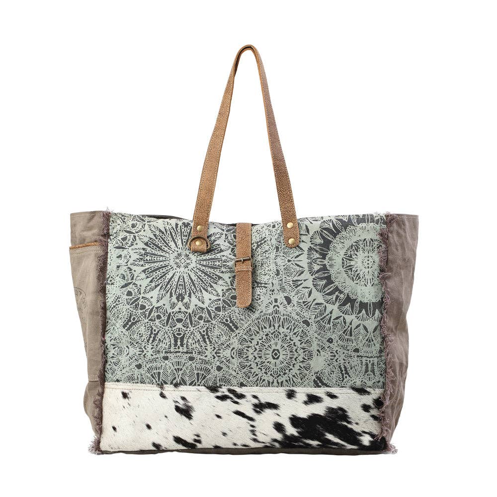Floral print weekender bag with leather trim, featuring top handles and a zipper closure for stylish travel.