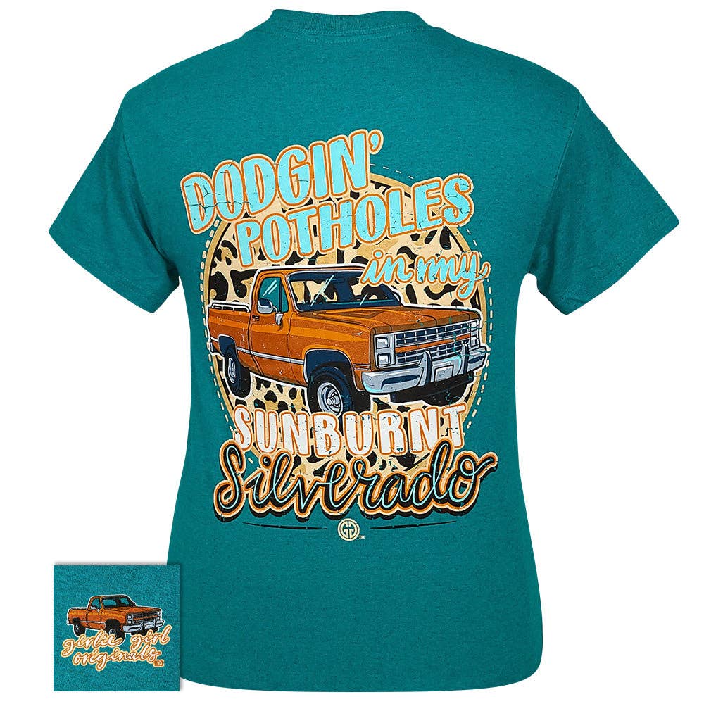 Teal Dodgin' Potholes Tee featuring a vintage Silverado truck design with leopard background and playful text.