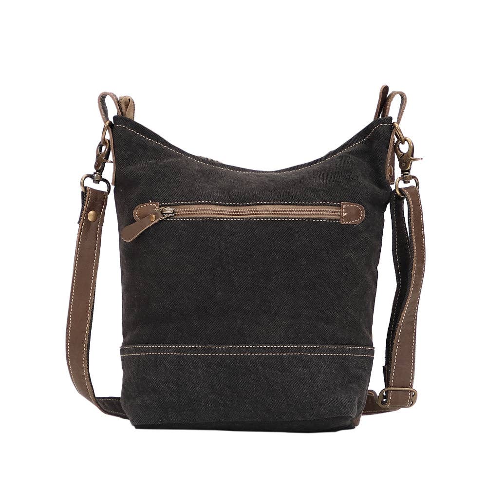 Shoulder bag featuring a front zippered pocket, adjustable strap, and soft textured design in a dark color.