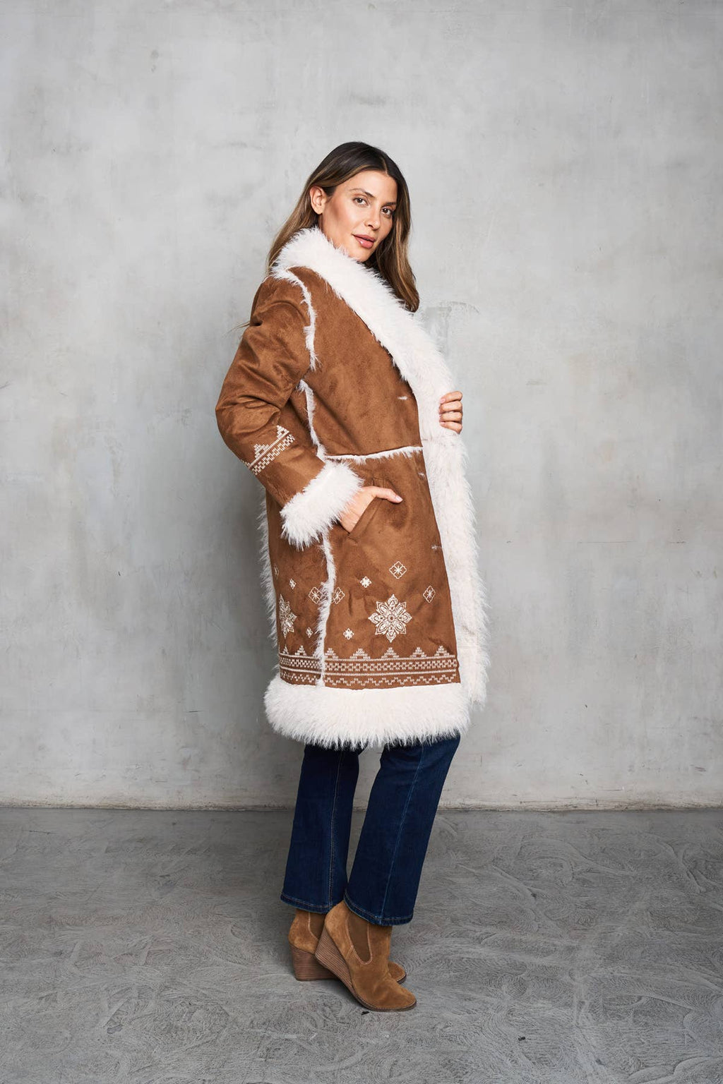 Faux suede camel coat featuring shearling trim, delicate embroidery, and inseam pockets for a stylish Western look.
