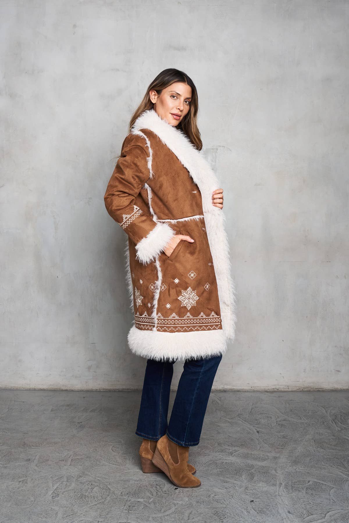 Faux suede camel coat featuring shearling trim, delicate embroidery, and inseam pockets for a stylish Western look.