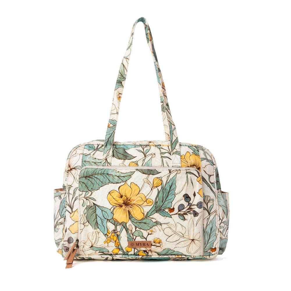 Floral-patterned diaper bag in ochre fern with two handles and multiple exterior pockets for spacious organization.
