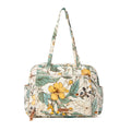 Floral-patterned diaper bag in ochre fern with two handles and multiple exterior pockets for spacious organization.