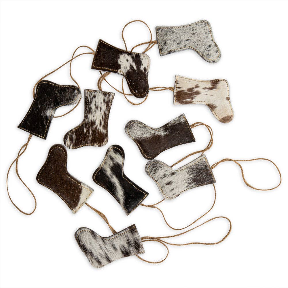 A set of ten unique black hair-on hide stockings with jute hangers, each showcasing distinct shapes and patterns.