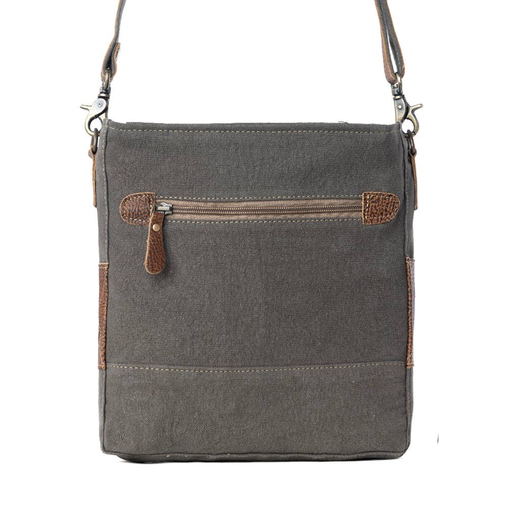 Floral canvas shoulder bag with hairon detail, featuring a zippered top closure and a neutral gray and brown color scheme.