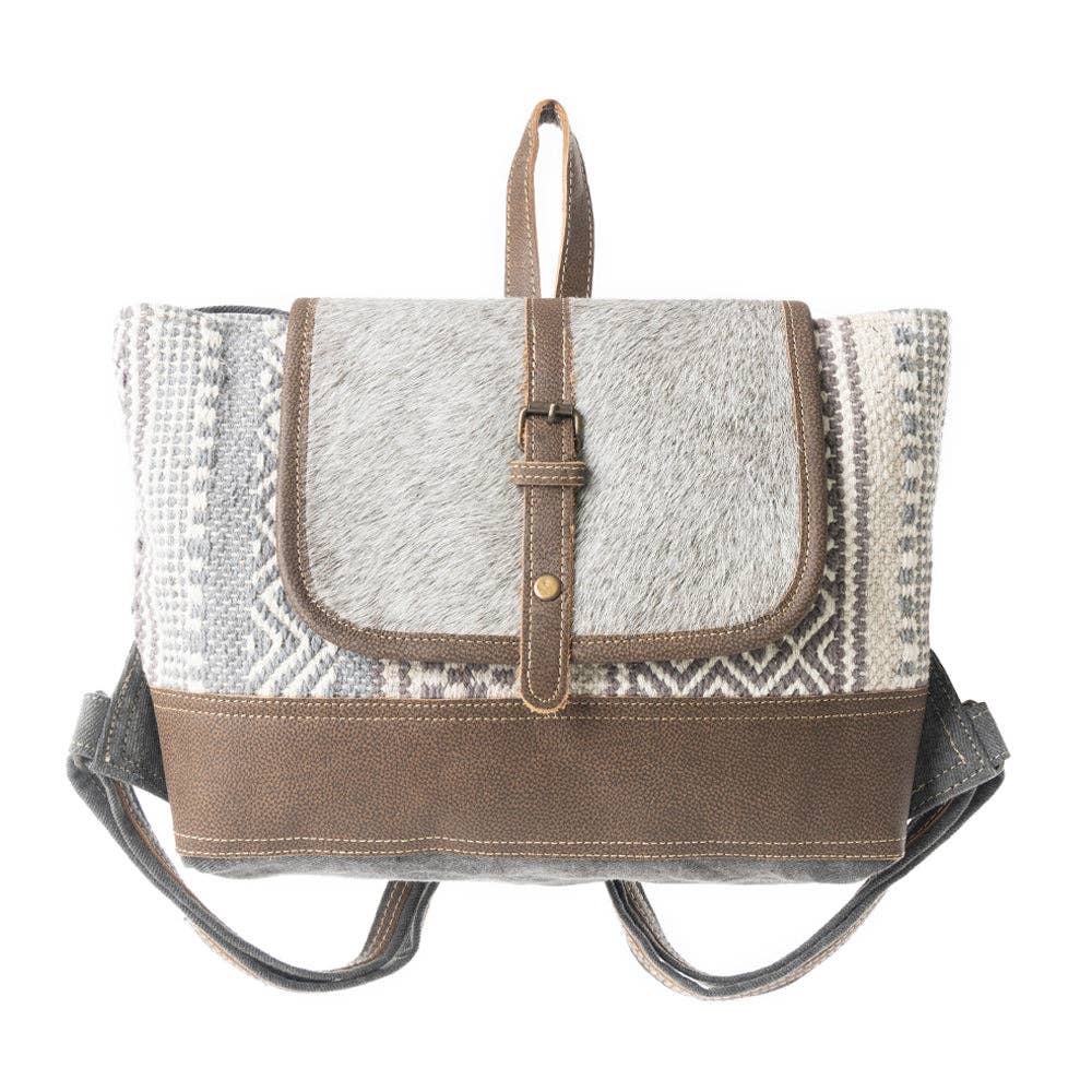 Grey and patterned backpack featuring a leather flap, adjustable straps, and a top handle for easy carrying.