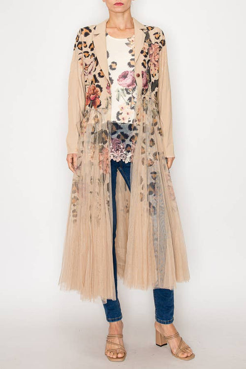 Longline blazer jacket with floral design and sheer mesh tulle panel, styled over a patterned top with jeans and sandals.