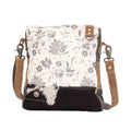 Floral design shoulder bag featuring a hairon panel, zippered top closure, and a comfortable shoulder strap.
