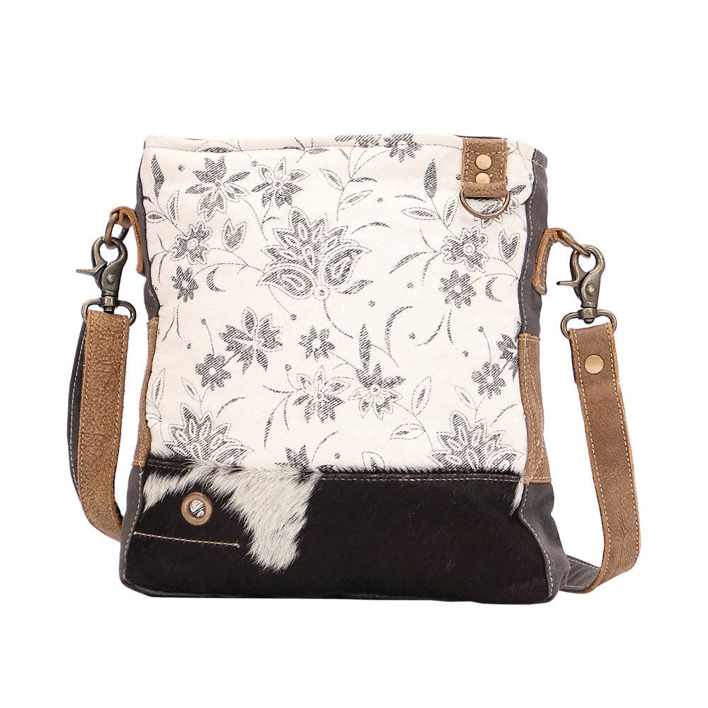 Floral design shoulder bag featuring a hairon panel, zippered top closure, and a comfortable shoulder strap.