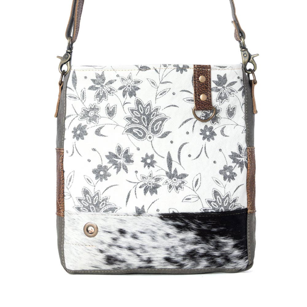 Floral design shoulder bag featuring a hairon panel, zippered top closure, and a stylish shoulder strap.