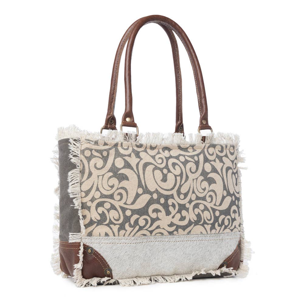 Leaf print small bag featuring a sturdy canvas and leather design, large main compartment, and zippered pocket inside.