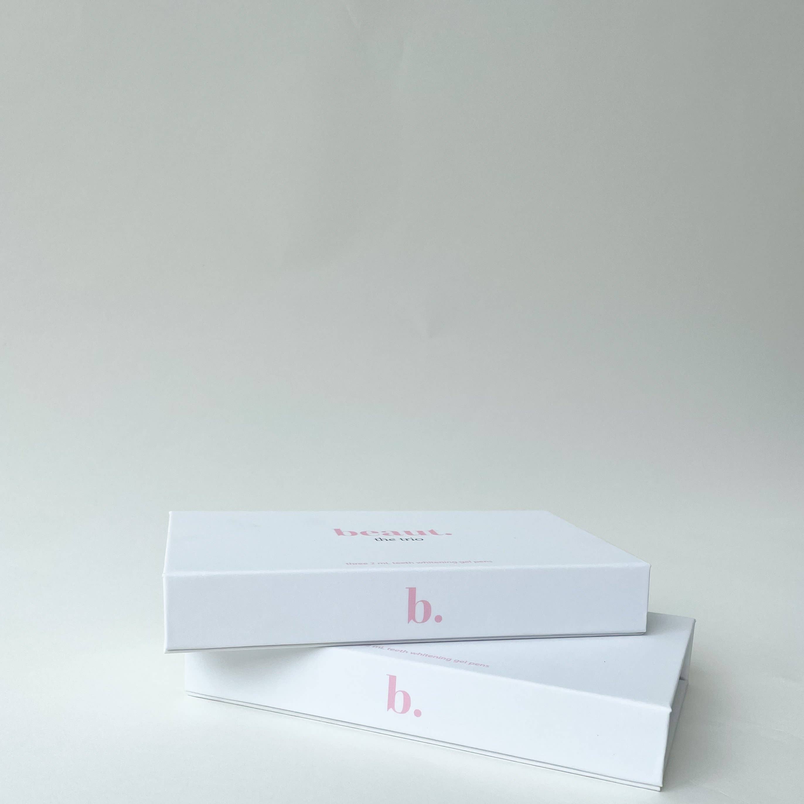 Two stacked white boxes featuring a pink letter 'b.' containing the 3 Smile Pens Pack: The Trio - Teeth Whitener.