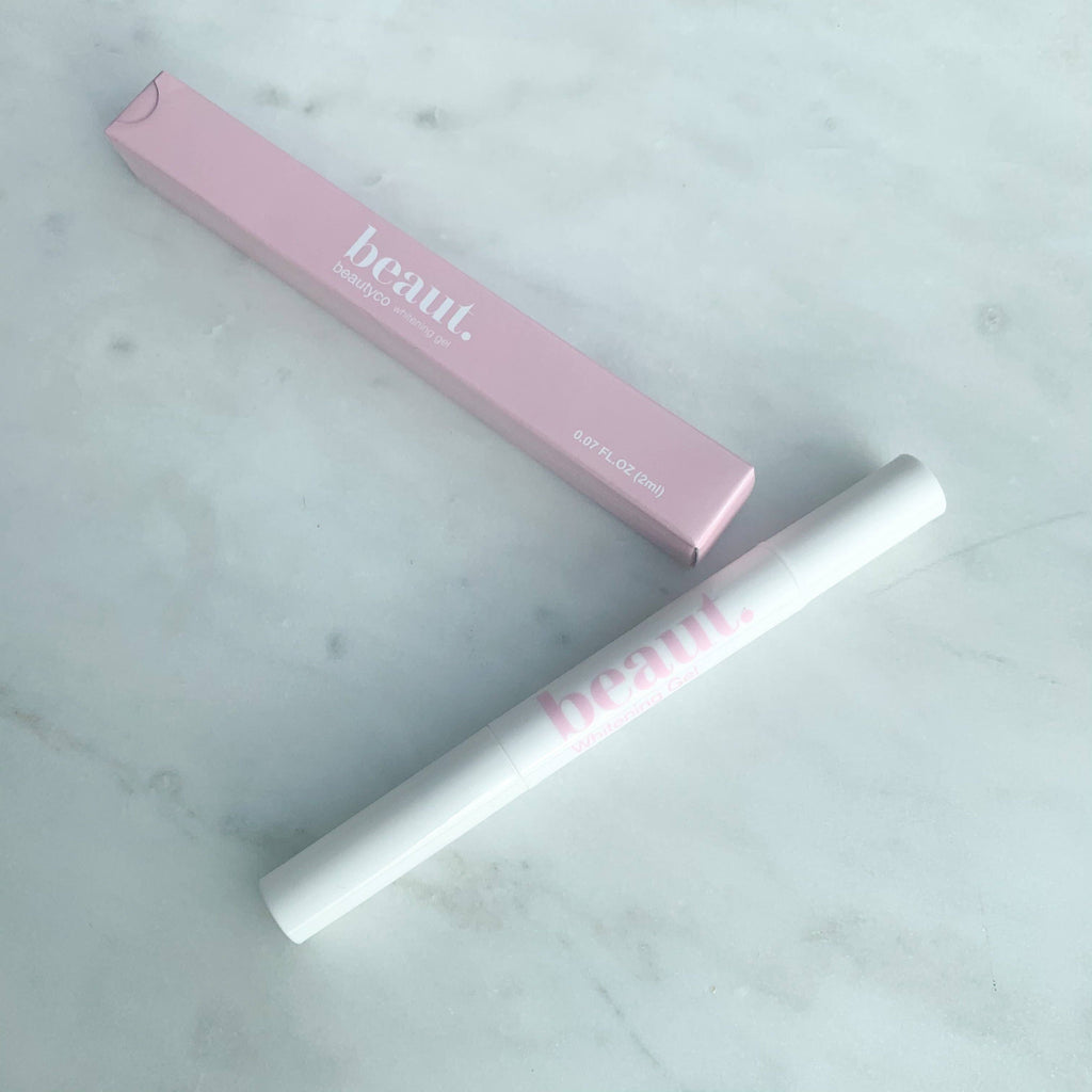 Pen-style teeth whitening gel applicator in a white body with a pink box, labeled 'beaut.' Ideal for at-home whitening treatments.