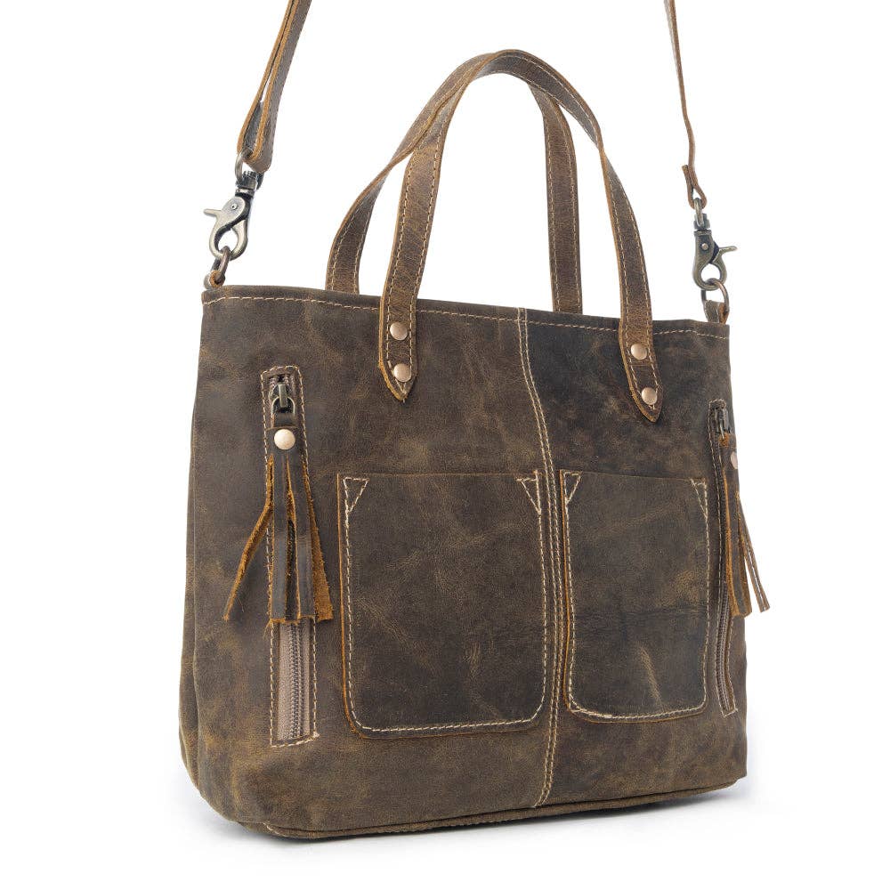 Dark brown leather handbag with fringed zippers, two top handles, and a shoulder strap, featuring front pockets for added style.