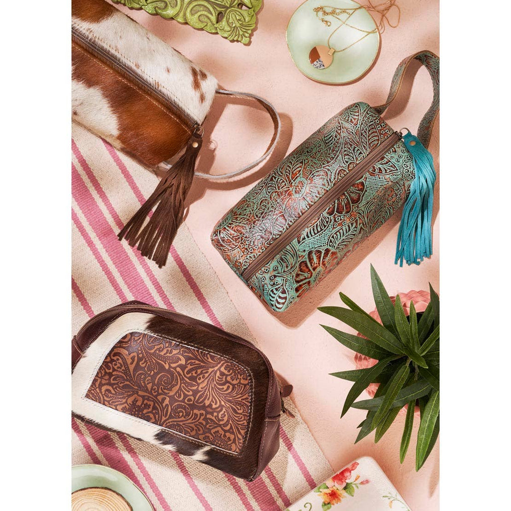 Multiple Wistful Skies Shaving Kits featuring hair-on hide and leather textures with fringe zippers and comfortable handles.