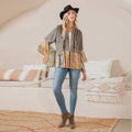 Kimono-style shrug with patchwork design, bell sleeves, and a casual look paired with jeans and a hat.