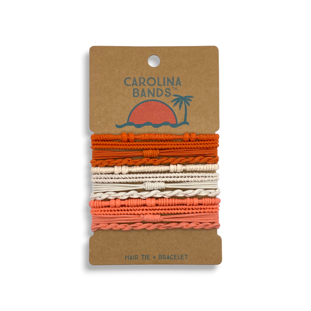 A set of colorful hair tie bracelets featuring orange, white, and pink, displayed on a card with a sunset and palm tree graphic.