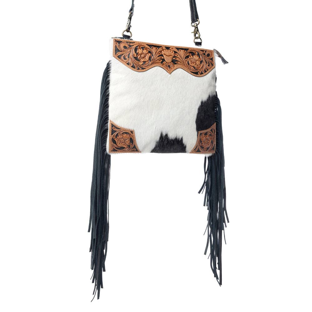 Hand-tooled caramel leather bag with a scalloped top panel, hair-on hide front, and black leather fringe.