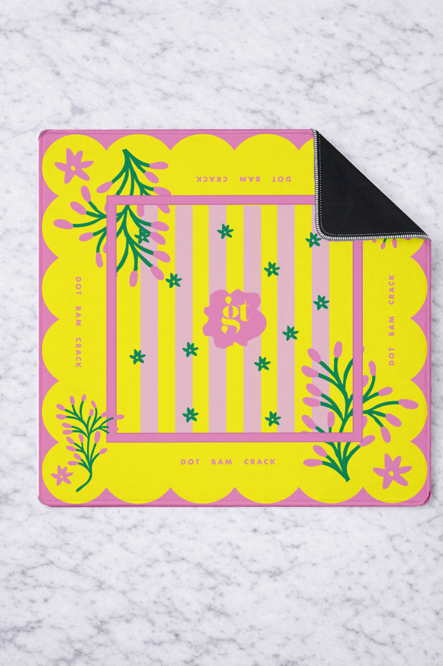 Vibrant yellow mahjong mat with pink scalloped edges and floral design, featuring a non-slip black underside for stable gameplay.