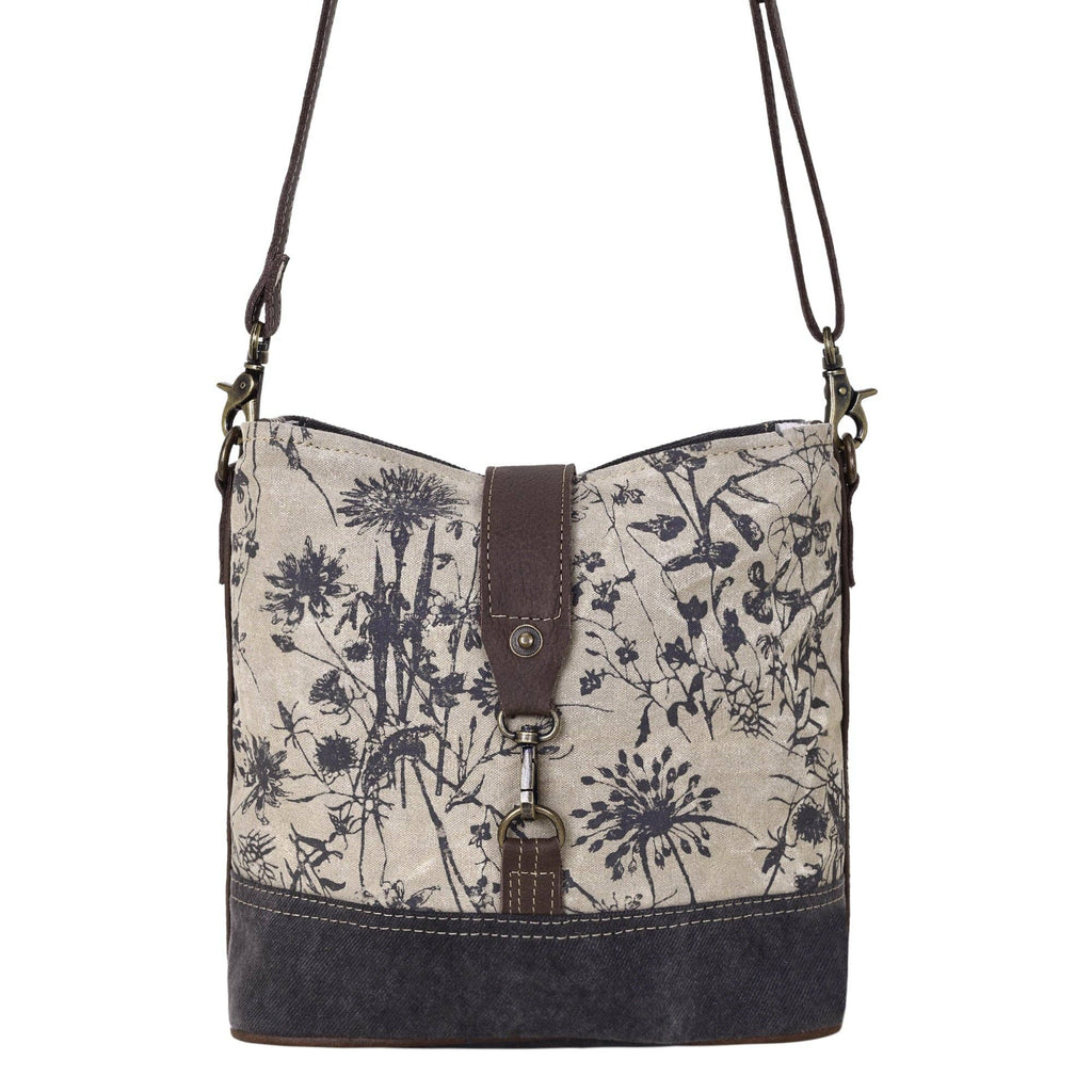 Floral canvas shoulder bag featuring a front lock closure and adjustable leather straps in a stylish two-tone design.