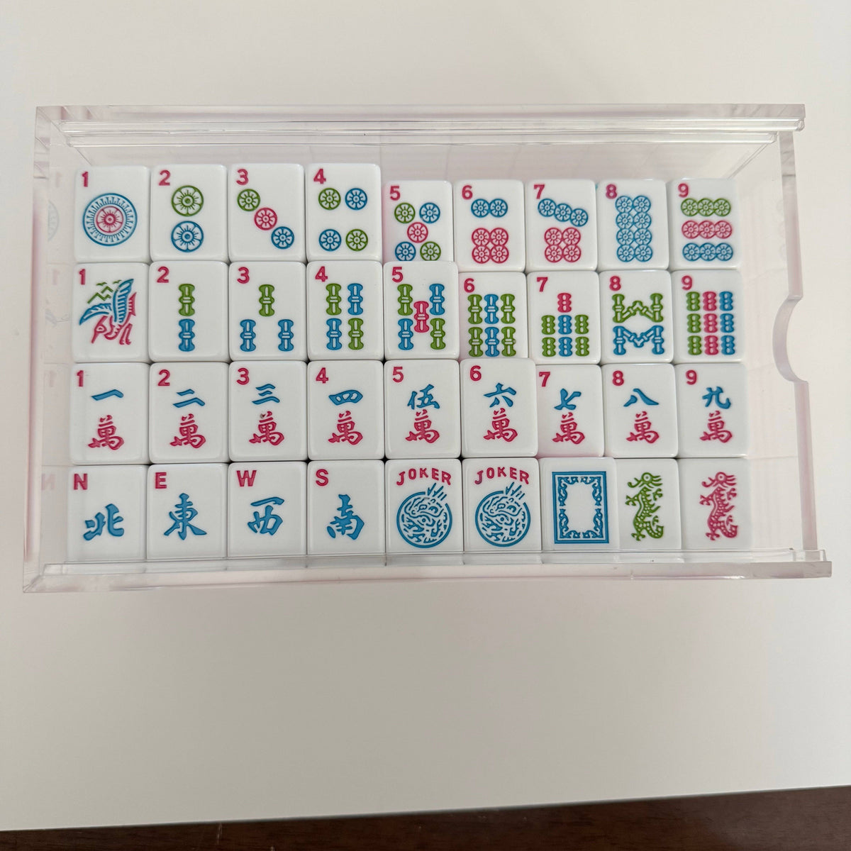 A beautifully organized Mahjong tile set featuring colorful designs, including dots, bamboo, and characters, ready for play.