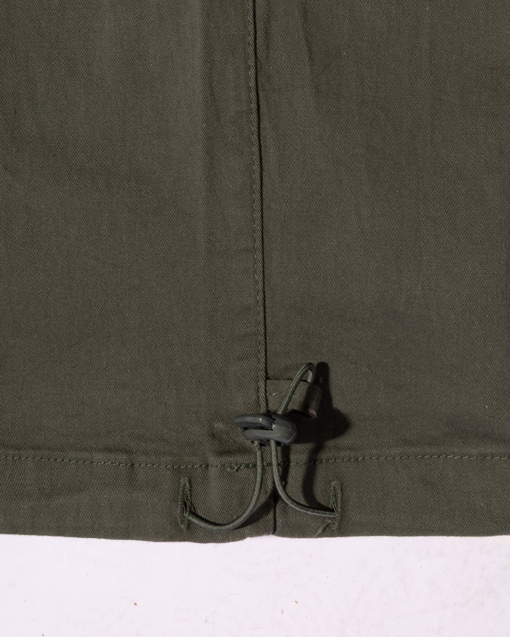 Close-up of the relaxed-fit waistband with a drawstring and toggle adjustment on cotton cargo pants.