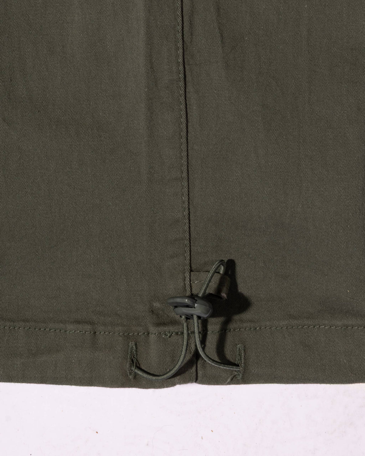 Close-up of the relaxed-fit waistband with a drawstring and toggle adjustment on cotton cargo pants.
