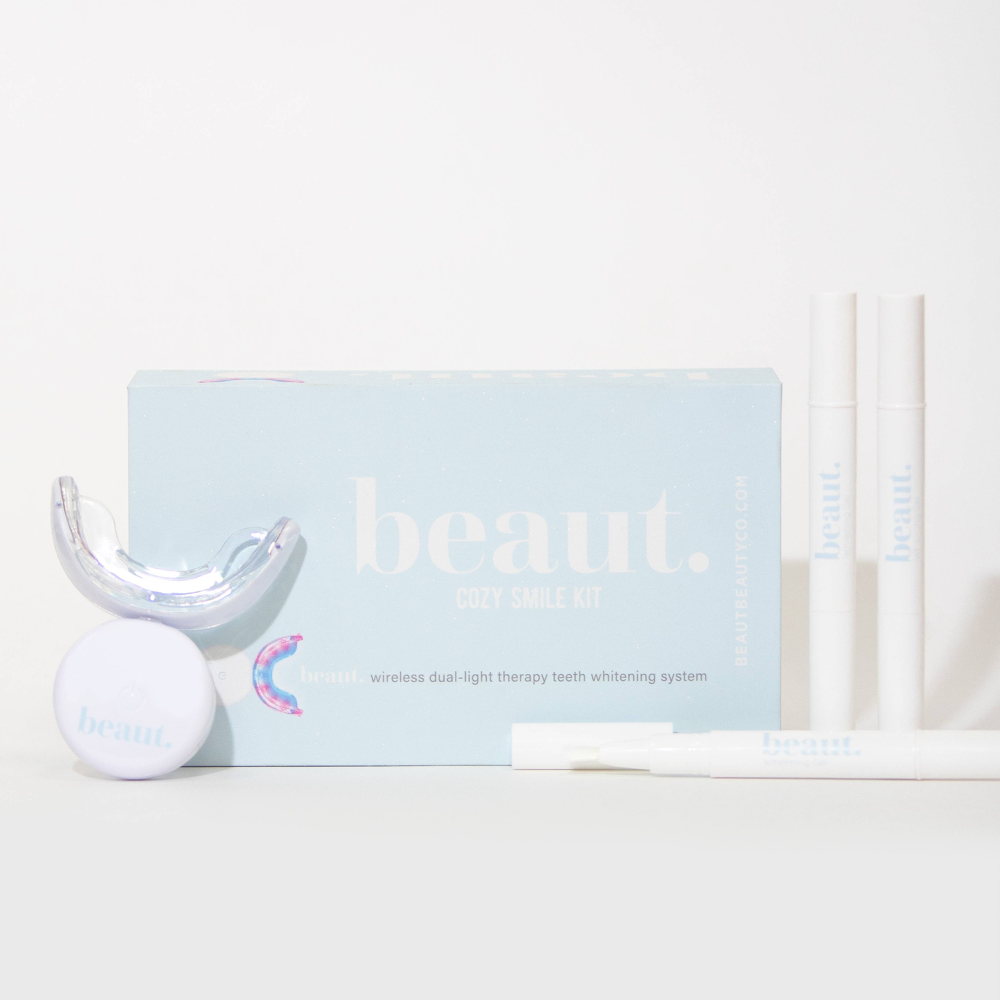 Mouthpiece and three whitening pens from the Cozy Kit for dental care and teeth whitening.