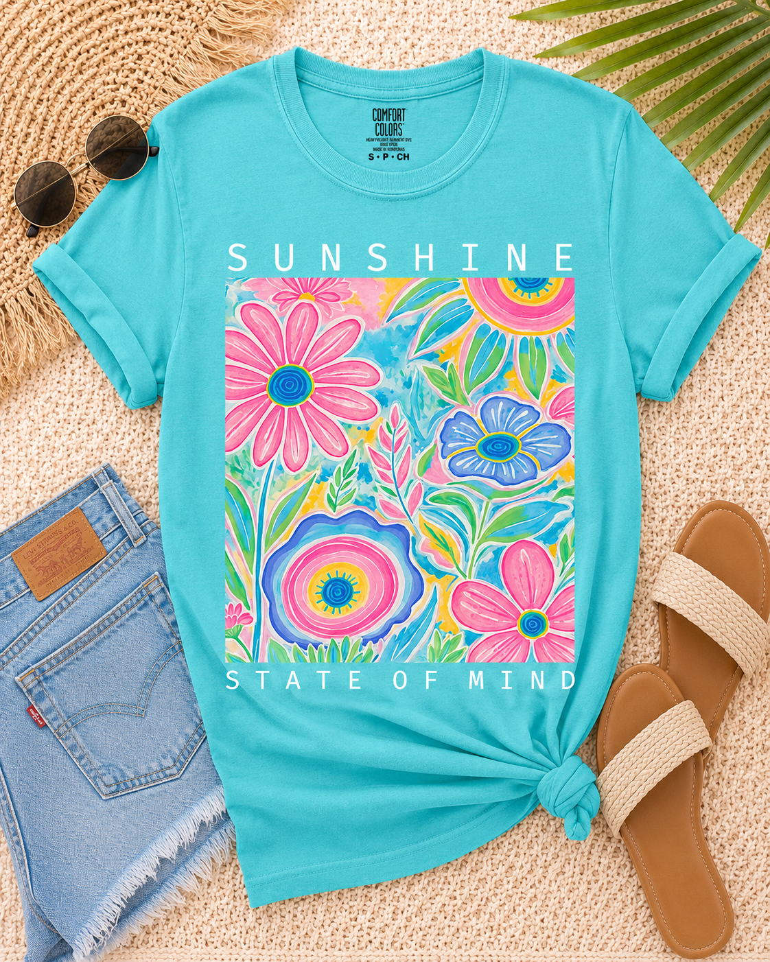 Vibrant turquoise Sunshine State of Mind Tee featuring a floral design and relaxed fit with rolled sleeves.