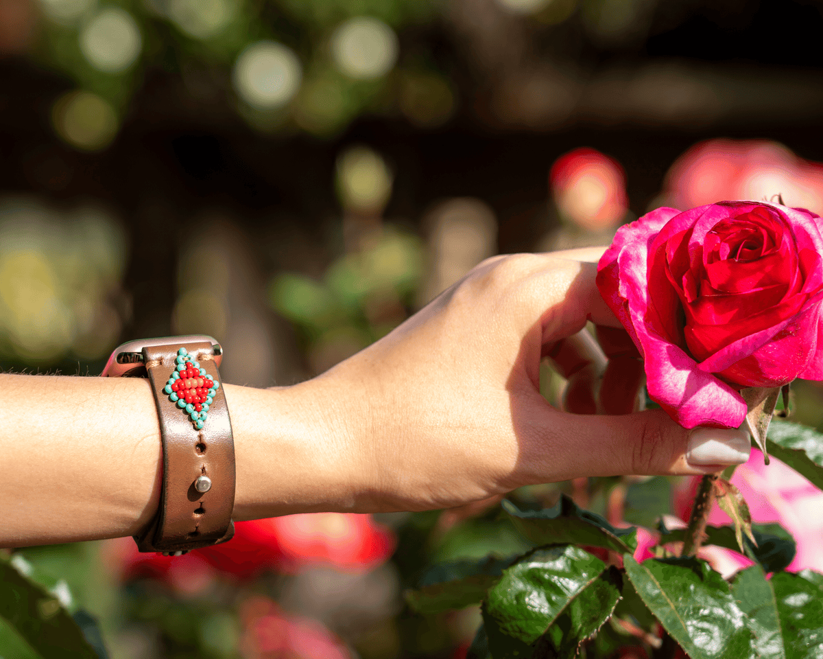 A stylish Biarritz Beaded Apple Watch Band featuring a red and turquoise design, perfect for adding a western flair to your look.