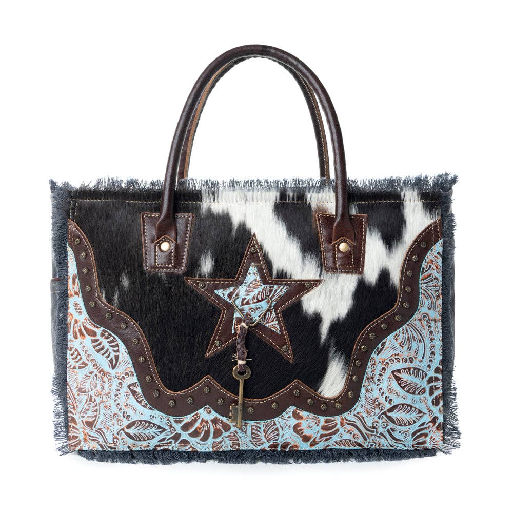 Stylish Articulate Canvas & Hairon Bag featuring a star design, fringe detail, and a mix of black, white, light blue, and brown accents.