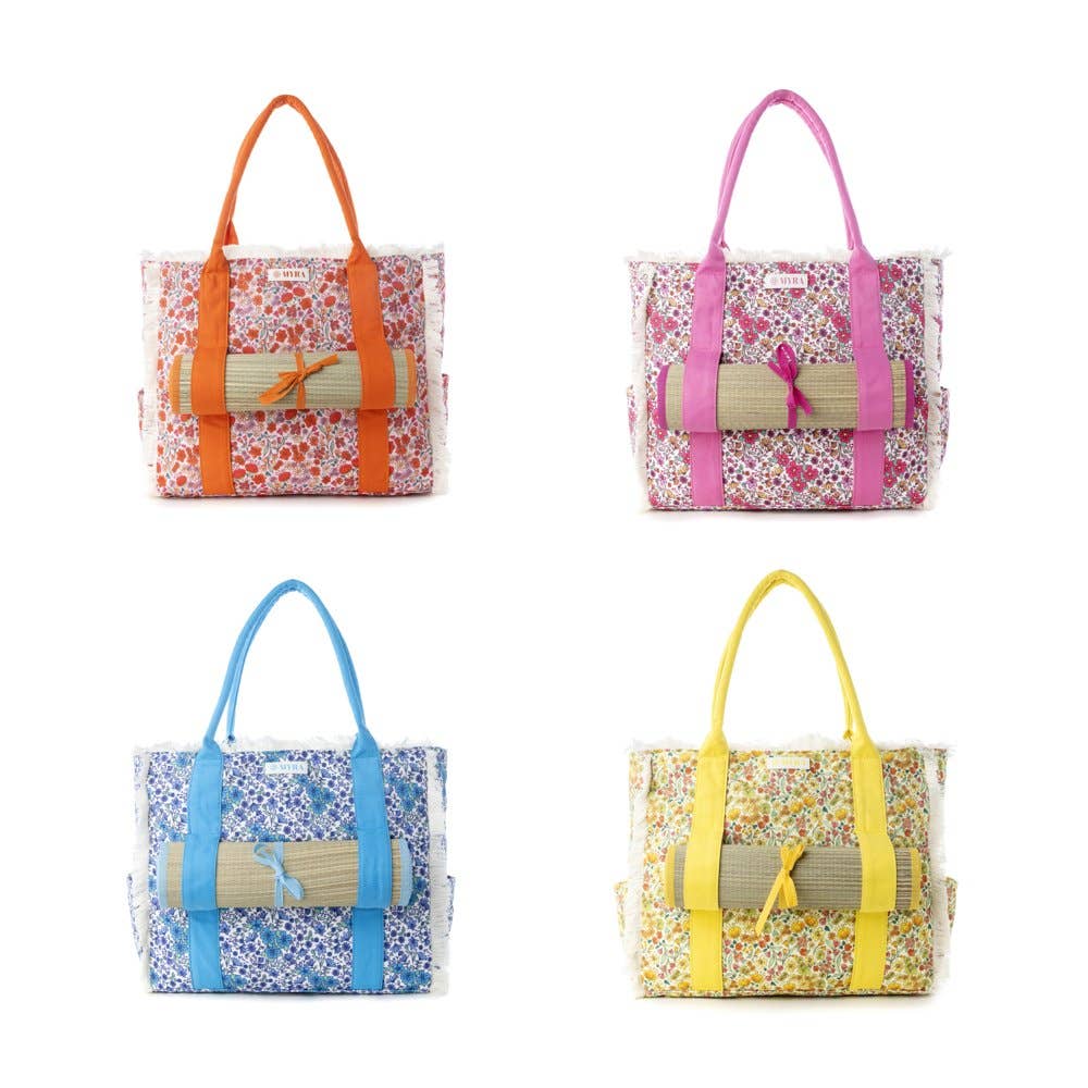 Shoreline Weekender Bag featuring a wildflower print body, fringe detailing, and colorful carry straps, includes a beach mat.